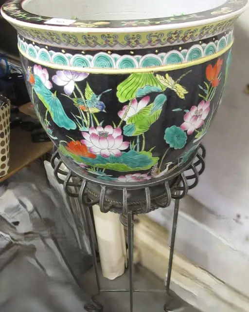 Thống sứ nền đen vẽ sen, đặt trên đôn sắt uốn